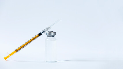 The vaccines vials glass bottle and disposable syringe on white
