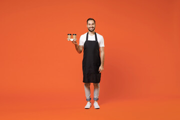 Full length young happy man barista bartender barman employee in apron white t-shirt work in coffee...