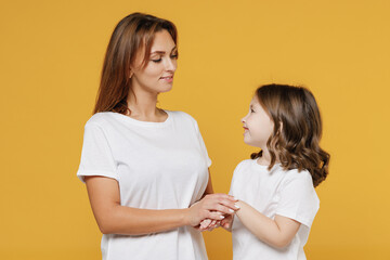 Happy woman in basic white t-shirt have fun with child baby girl 5-6 years old hold hands. Mom...