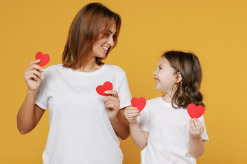Happy woman in basic white t-shirt have fun with child baby girl 5-6 years old hold heart. Mom...