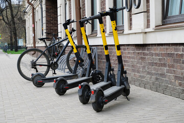 Scooters and bicycles in a parking lot in the city. The concept of modern transport