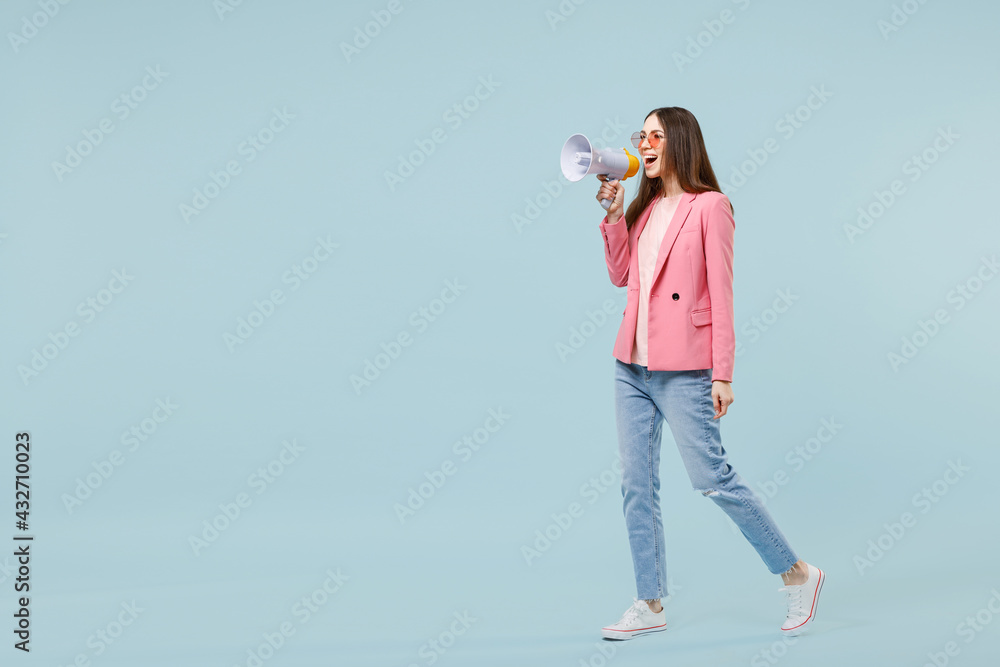 Wall mural full length side view young fun happy caucasian woman in pastel pink clothes glasses scream shouting