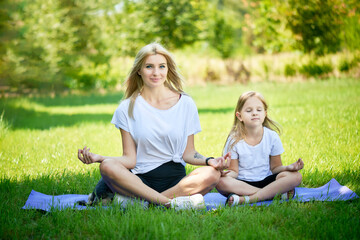 mother practicing yoga with toddler daughter