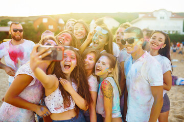 A group of friends have fun,  dance at the holi festival. Spring Break Beach Party. Celebrating traditional indian spring holiday. Friendship, Leisure, Vacation, Togetherness.