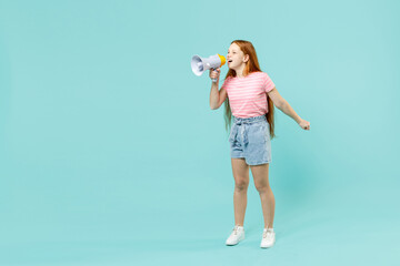Full length little redhead kid girl 12-13 years old wear pink striped t-shirt scream in megaphone shout hot news aside isolated on pastel blue background studio Children lifestyle childhood concept