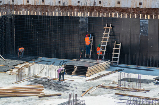 Workers make metal reinforcement for the concrete foundation.