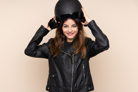 Woman with a motorcycle helmet isolated on beige background
