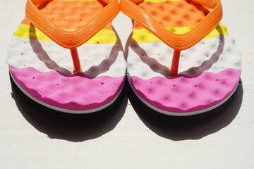 Colored beach flip flops on a white table
