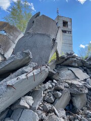 Ruined abandoned factory, concrete texture, trees among concrete and cement on a background of sky with clouds