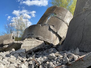 Ruined old concrete building, remnants of civilization, ruins against the sky with clouds, concrete structures