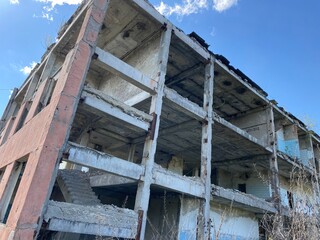 Ruined old concrete building, remnants of civilization, ruins against the sky with clouds, old city