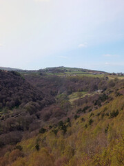 Obraz premium view along the colden valley in calderdale near hebden bridge with the village of colden on the hills above the woodland