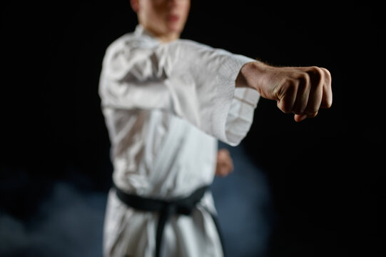 Male karateka, fighter practice in white kimono
