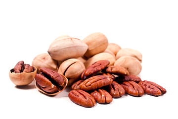 Heap of whole and cracked pecan nuts isolated on a white background.