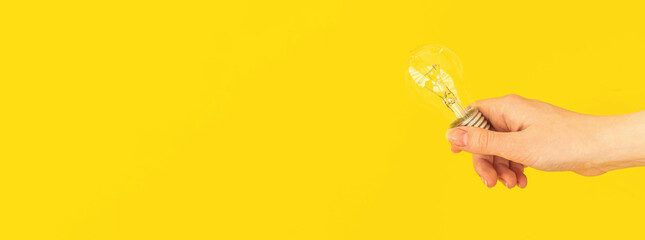 Banner hand holding light bulb on yellow background, new idea concept background with copy space