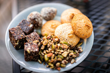 Flat top above closeup view of cookies on plate stack pile with raisin oatmeal vegan oat ingredient on wooden table
