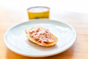 Canned cod liver in oil closeup macro of spread fish on toast bread plate on table with background of can as healthy omega 3 rich food popular in Russian cuisine