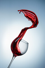 Splash of red wine poured into a glass