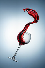 Splash of red wine poured into a glass