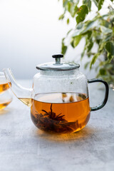 Chinese flower tea brewed in a transparent teapot with two cups . Vertical format 