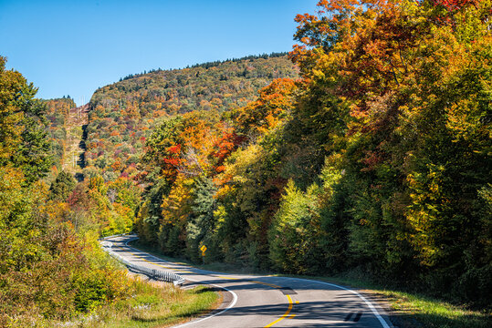 Winding turning curve highway road in Snowshoe town, Allegheny mountain ski resort village of West Virginia in colorful autumn fall with maple trees foliage
