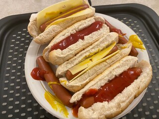 Hot dogs grouped on large plate and tomato sauce