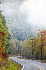 Vertical view of foggy mist misty rural countryside scenic highway in West Virginia in fog fall...