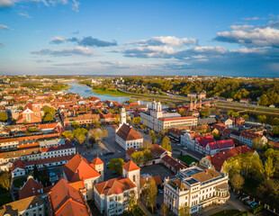 Aerial view of a sunny day in Kaunas city town hall square with red roof tops, towers of churches, cathedral and Nemunas river around