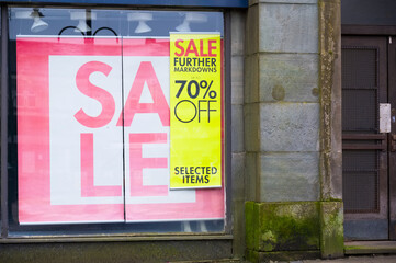 Summer clearance sale now on sign in shop window