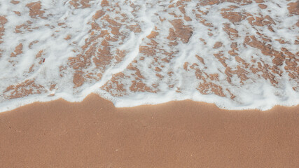 Sea wave in the golden sand of the beach of Tarragona, Spain.