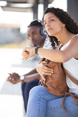 woman looking at her watch at bus station