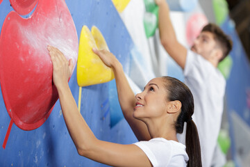 attractive man and woman on indoor climbing wall