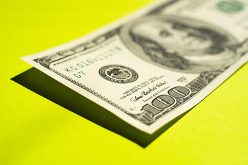 100 dollar bill on a bright green table close-up.