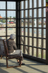 Samotna stara siwa kobieta siedząca sama na ławce