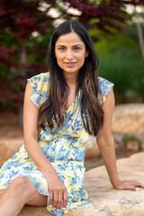 Beautiful Asian Indian woman sitting by a small creek