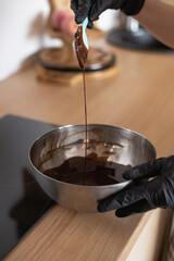 pastry chef melted chocolate; hand-made chocolate; pastry chef melted chocolate in an iron bowl