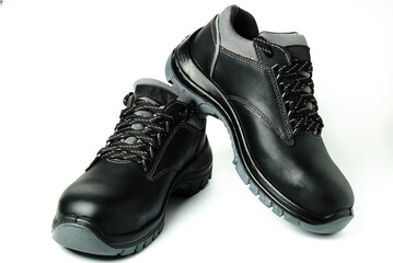 Pair of black leather work safety boots isolated on white. Industrial personal protective...