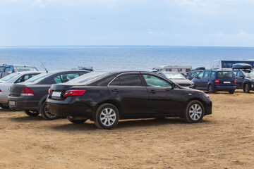 Fototapeta na wymiar Cars on the sandy seashore