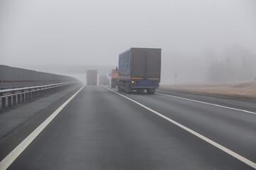 Obraz na płótnie Canvas Trucks are moving in the fog