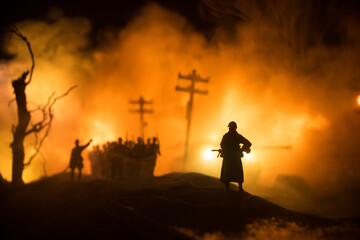 War Concept. Military silhouettes fighting scene on war fog sky background, World War Soldiers Silhouette Below Cloudy Skyline At night. Battle in ruined city.