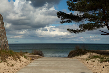 Zugang zum leeren Strand und Meer, an der Ostsee auf Rügen in Mecklenburg-Vorpommern, während Corona, in Prora mit Wolken am Himmel