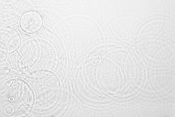 Fototapeta na wymiar de-focused. Blurred desaturated transparent clear calm water surface texture with ripples, splashes and bubbles. Trendy abstract nature background. White-grey water waves in sunlight. Copy space.