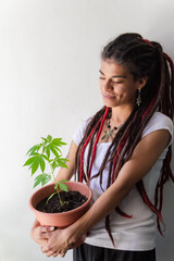 woman holding a marijuana plant
