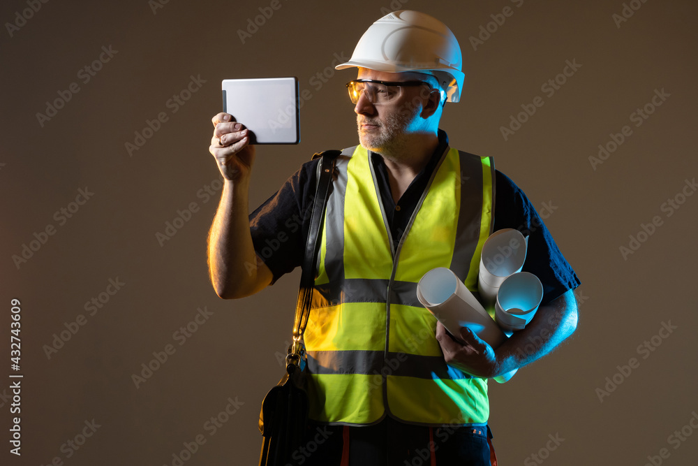 Poster builder with tablet computer. he is holding tablet with construction application. concept is applica