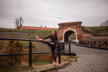 one young woman stretching outdoors, on a winter day.