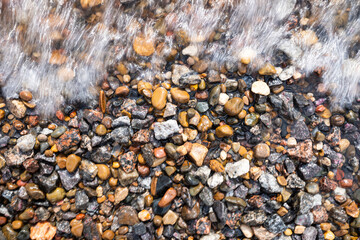 the water washes the multi-colored pebbles on the shore. flat lay.