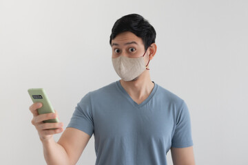 Asian man with mask is happy with the promotion in the smartphone application.