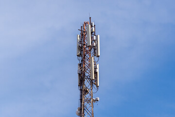 Cellular tower with antennas against the sky.
