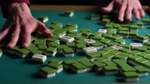 the mahjong player shuffles the tiles before playing