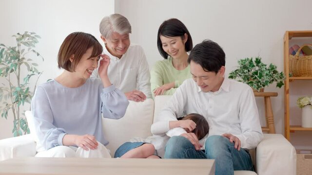 リビングでリラックスする三世代家族